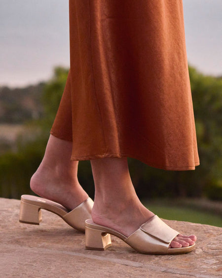 Model wearing Avenue Slide Metatarsal in color Light Gold Leather