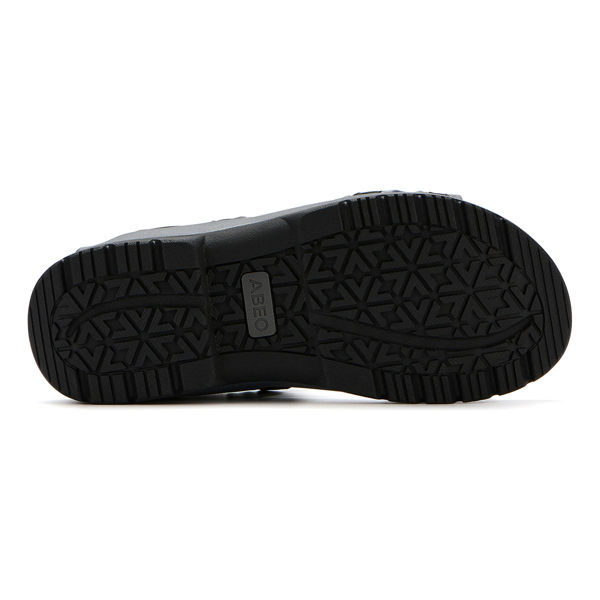 The image displays the black rubber outsole of the ABEO Goleta Trail sandal, featuring a patterned tread for enhanced traction and an embossed ABEO logo at the center. Engineered for durability and comfort, these water-resistant sandals provide orthotic footbed support, making them an excellent choice for active lifestyles.